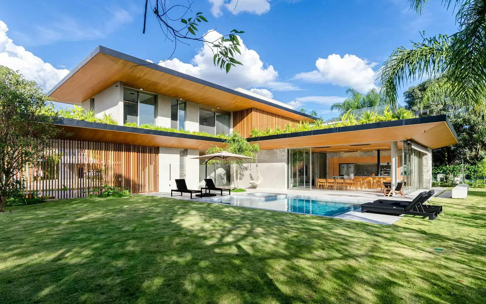 The villa seen from the lawn, with the lap pool along its length