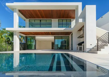 White villa with a timber soffit and a long pool at Moka